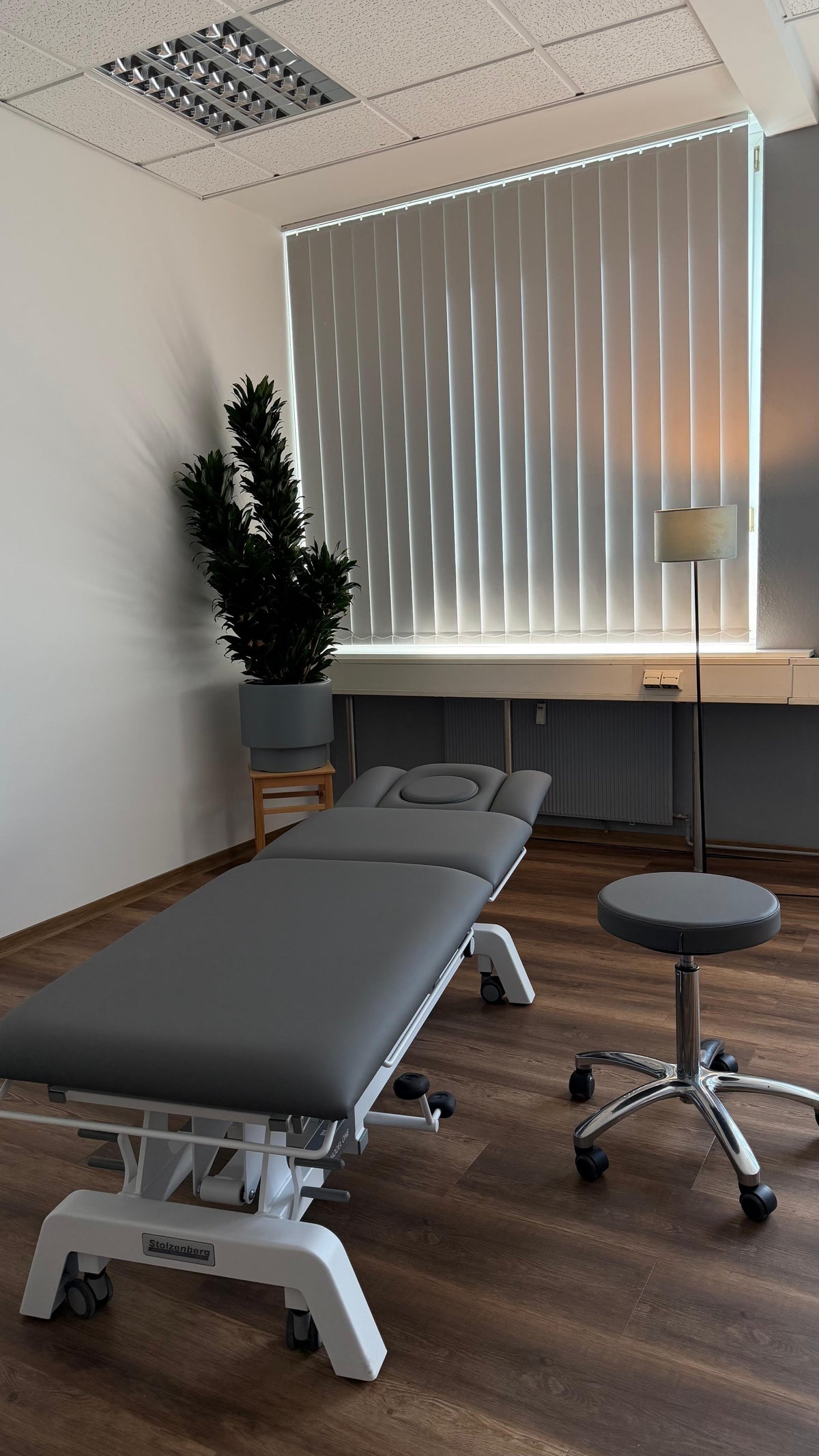 Heller Behandlungsraum mit Therapieliege für Anamnese und Assessment